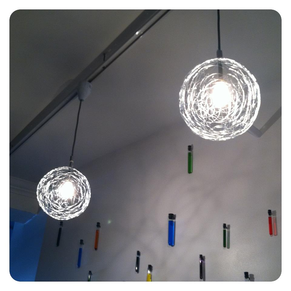 Galvanized wire pendant lights with test tubes decorating a wall