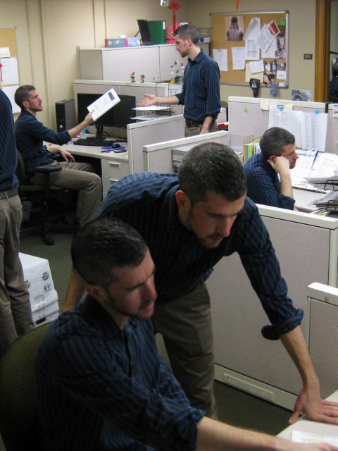 Photoshopped composite image of 11 clones in an office