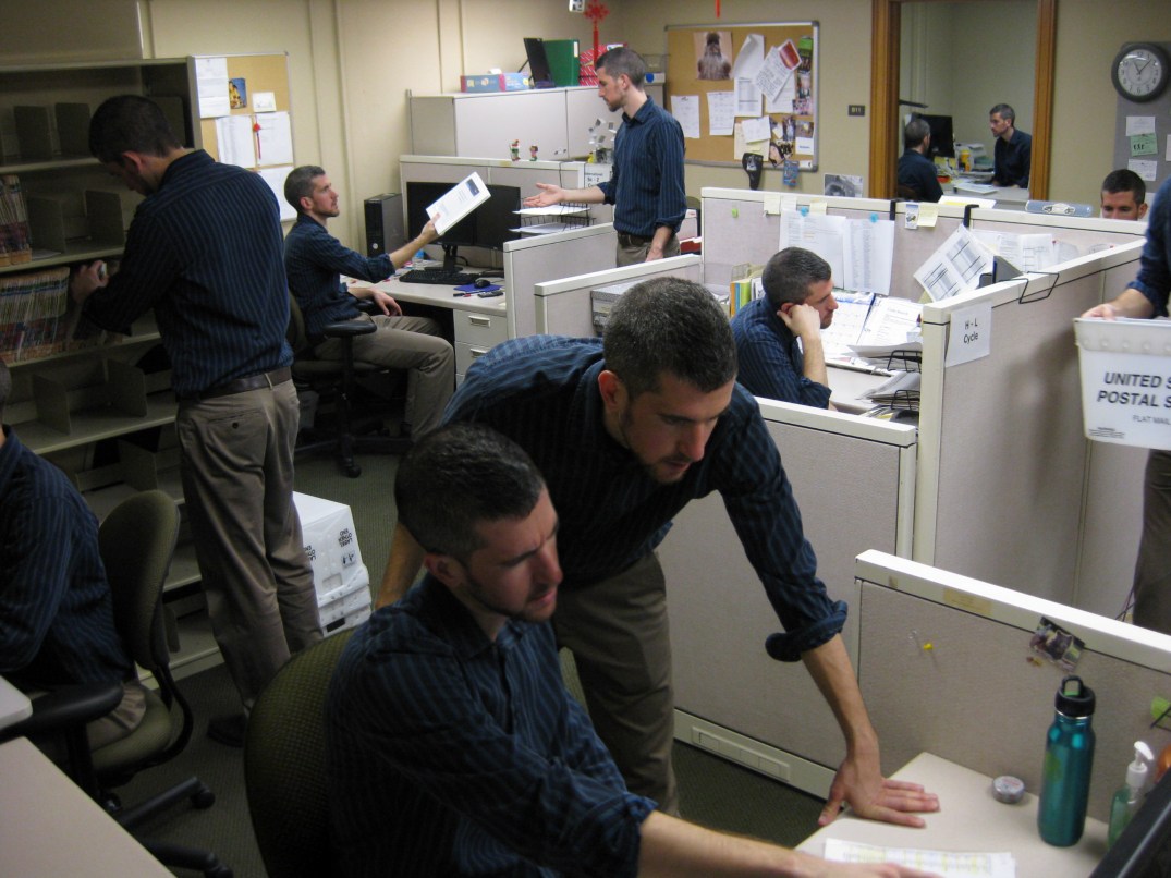 Photoshopped composite image of 11 clones in an office